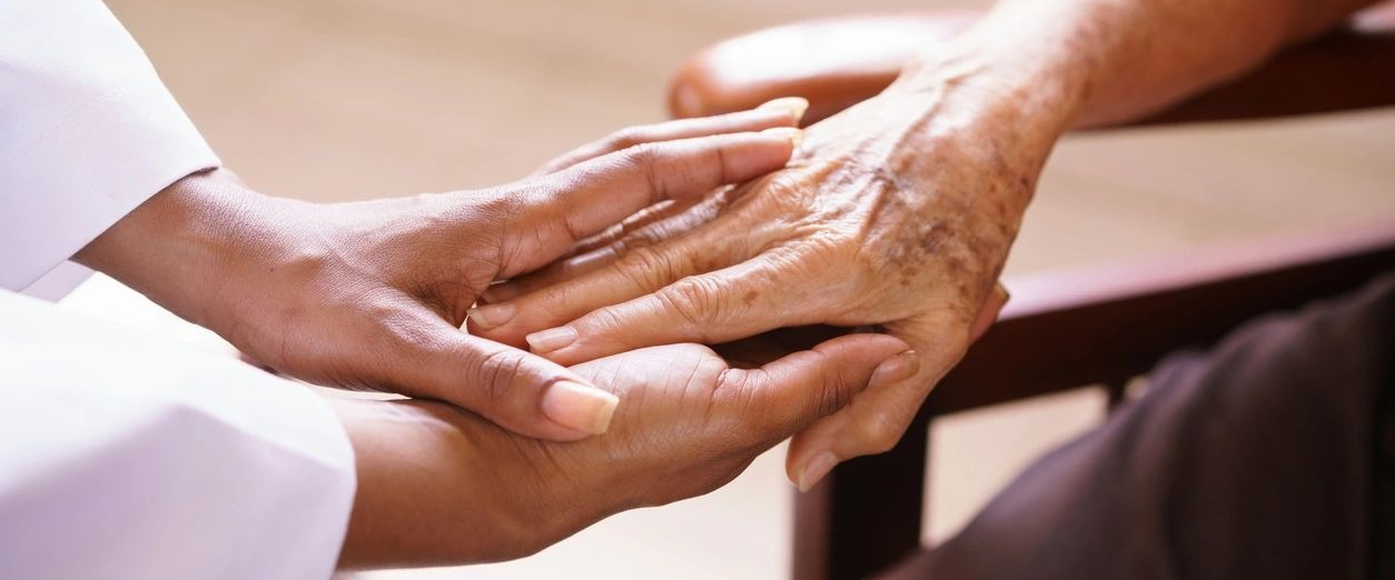 A person holding their hands over another persons hand.